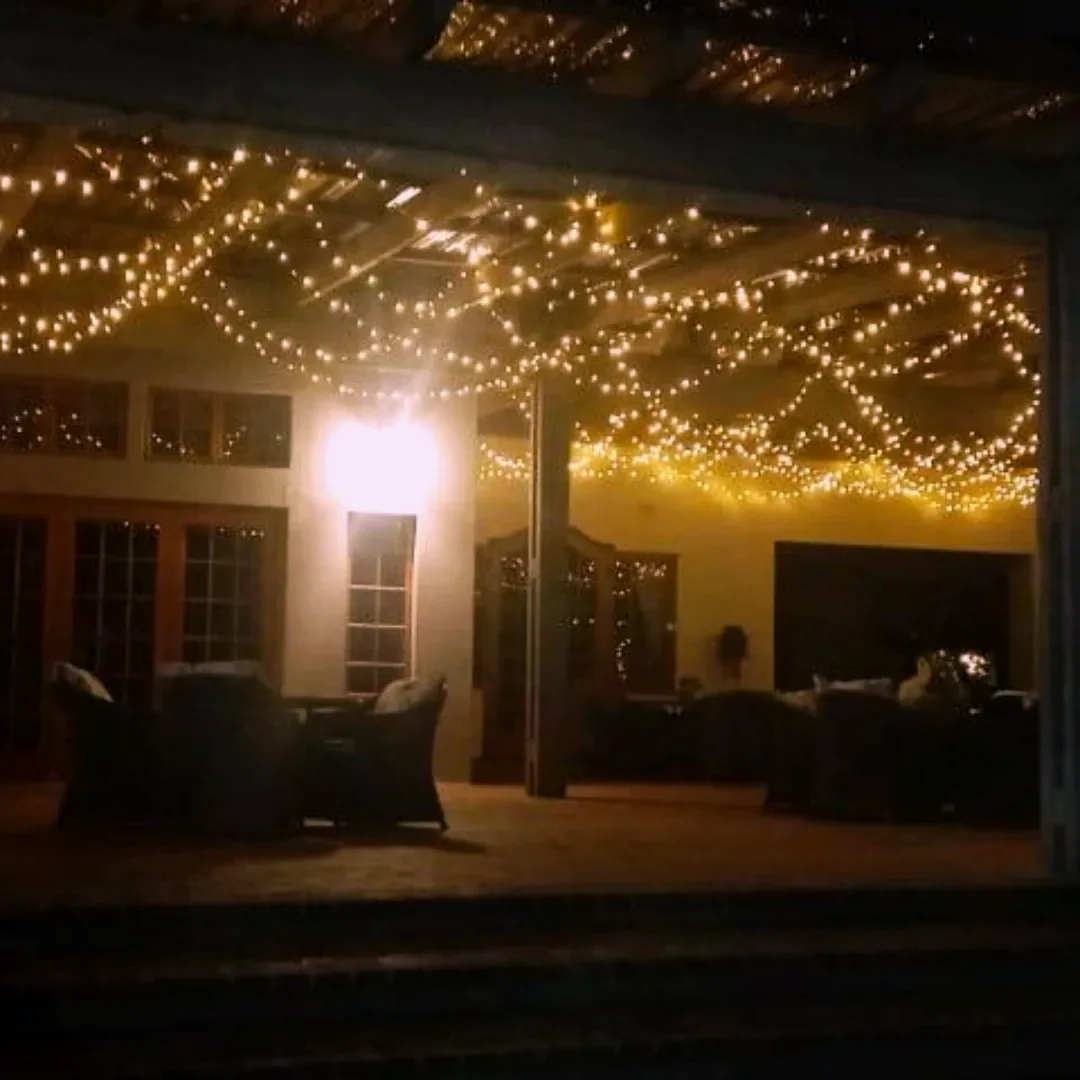 A veranda beneath swagged warm fairy lights at night