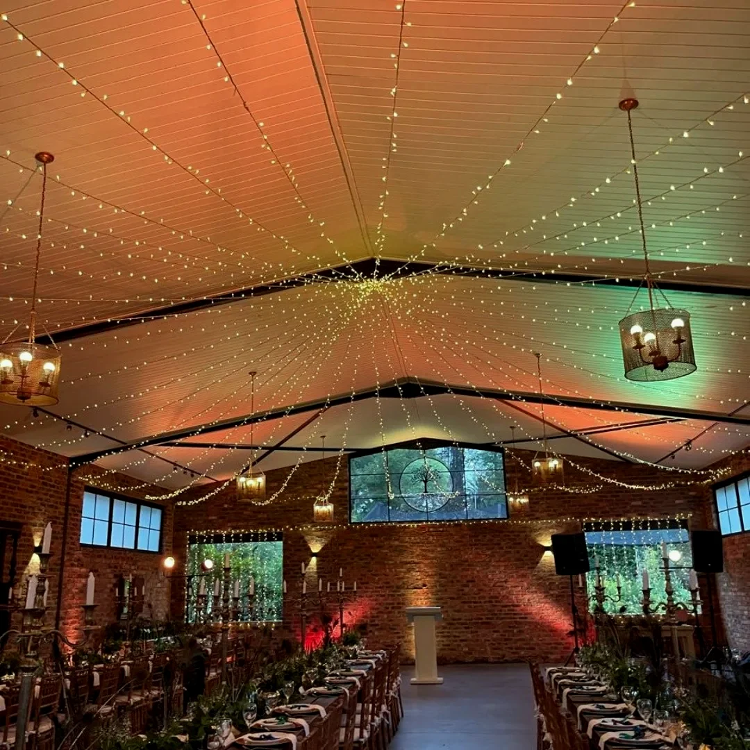 A large marquee interior lit with festoon lines and warm uplighting