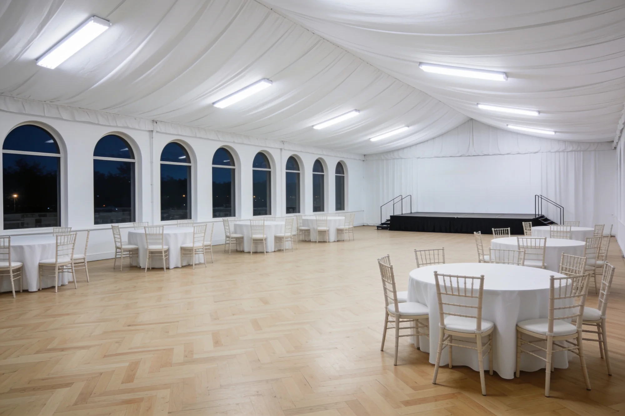 A bare function hall lit only by the plain white fixtures in its ceiling